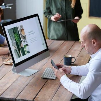 Group of professionals working together, using modern technology in a casual office setting.